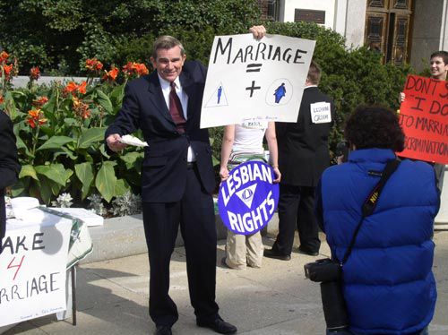 Lesbian bride and groom face crowds with their backs and their name placards on their back to protest PA marriage celebration.